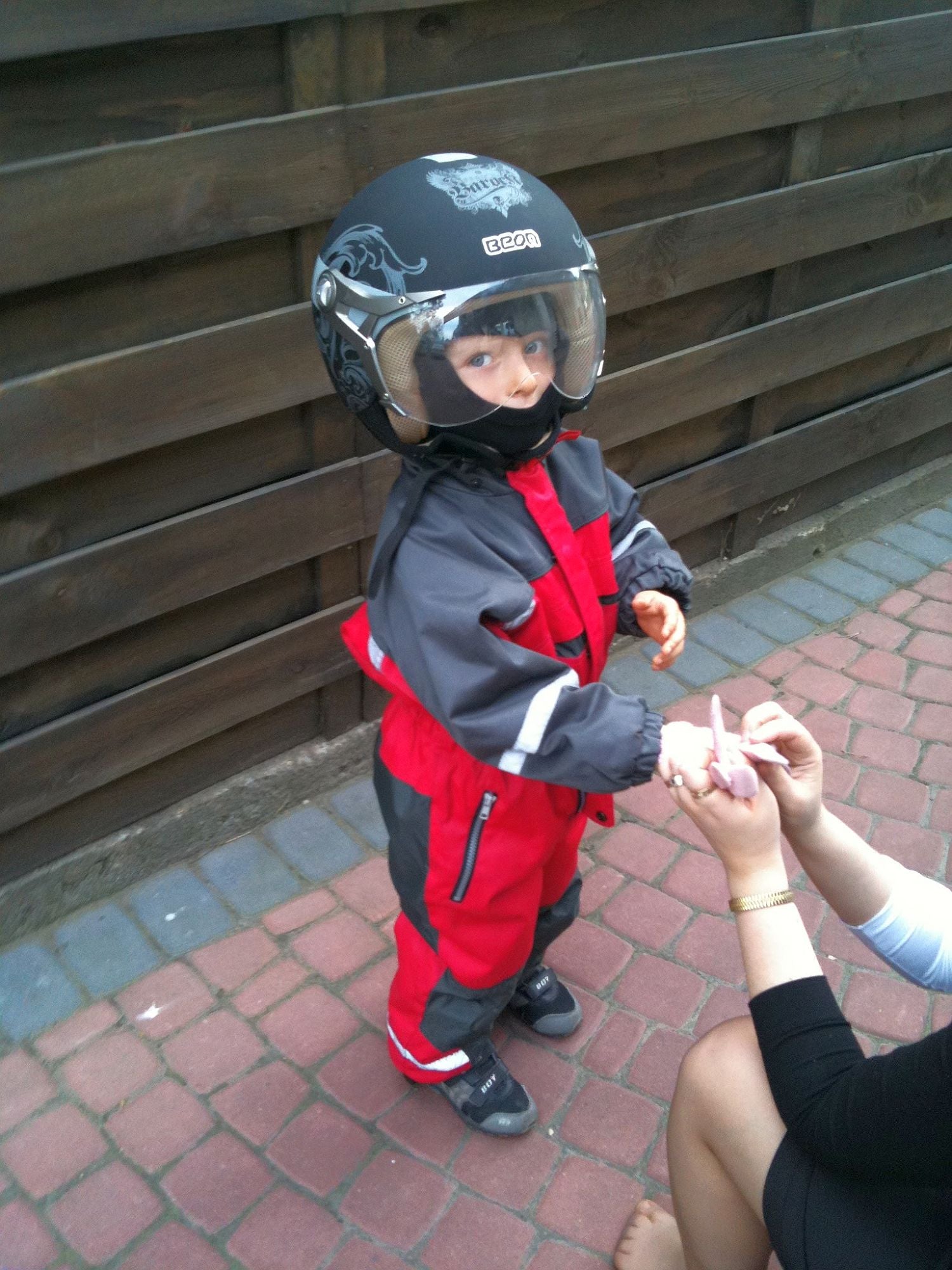 Dziecko w kombinezonie i kasku motocyklowym